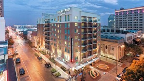A Courtyard Marriott hotel with a brick facade, multiple balconies, and a Starbucks on the ground floor.
