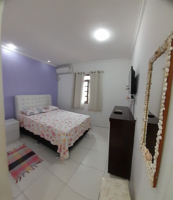A bedroom with a bed, a TV, a desk, and a window. - Casa de Maria (Angra dos Reis)