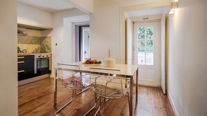 Une cuisine moderne dotée d’un four encastré et d’un coin repas avec une table et des chaises en verre.
