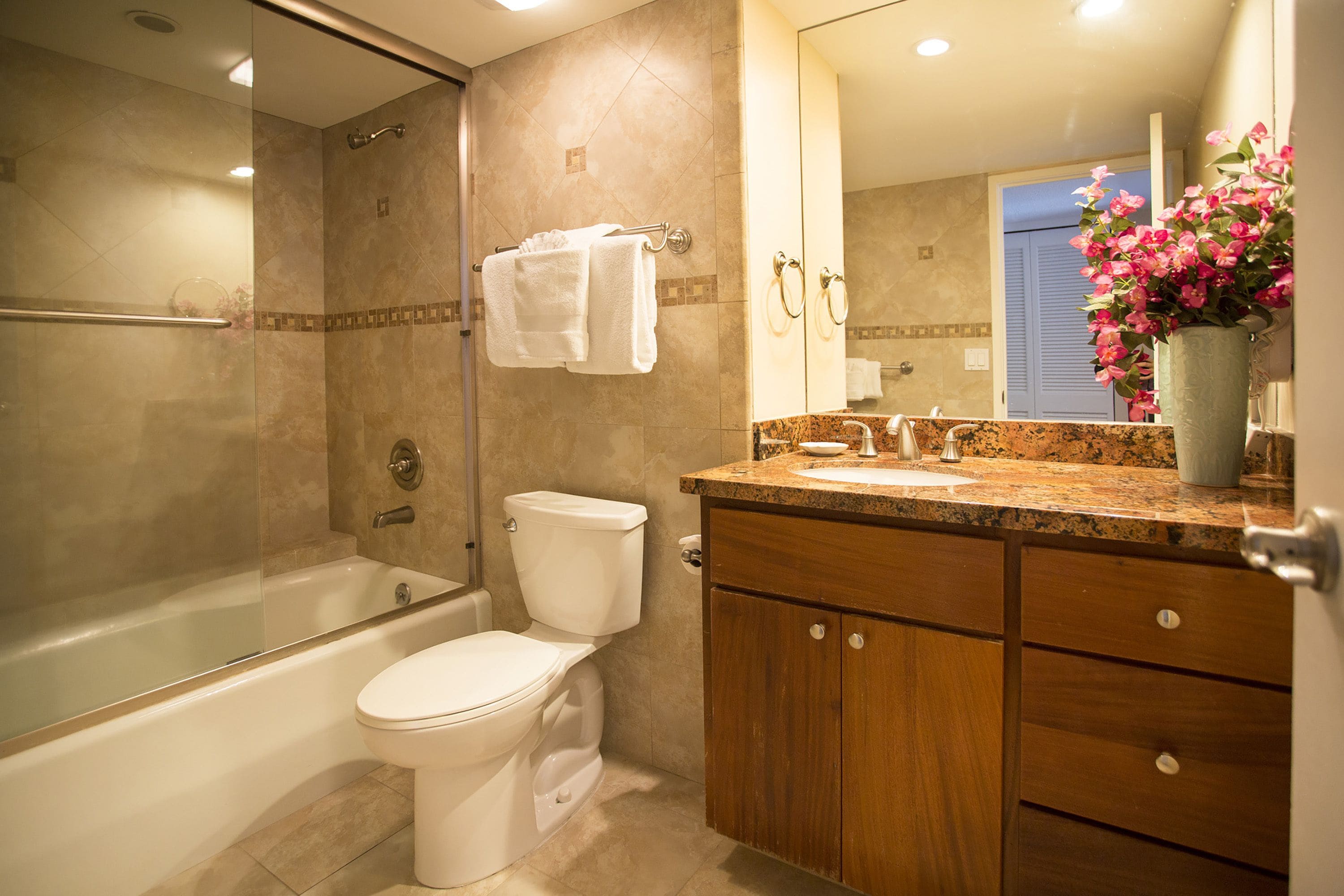Un baño con bañera, inodoro y tocador con lavabo.