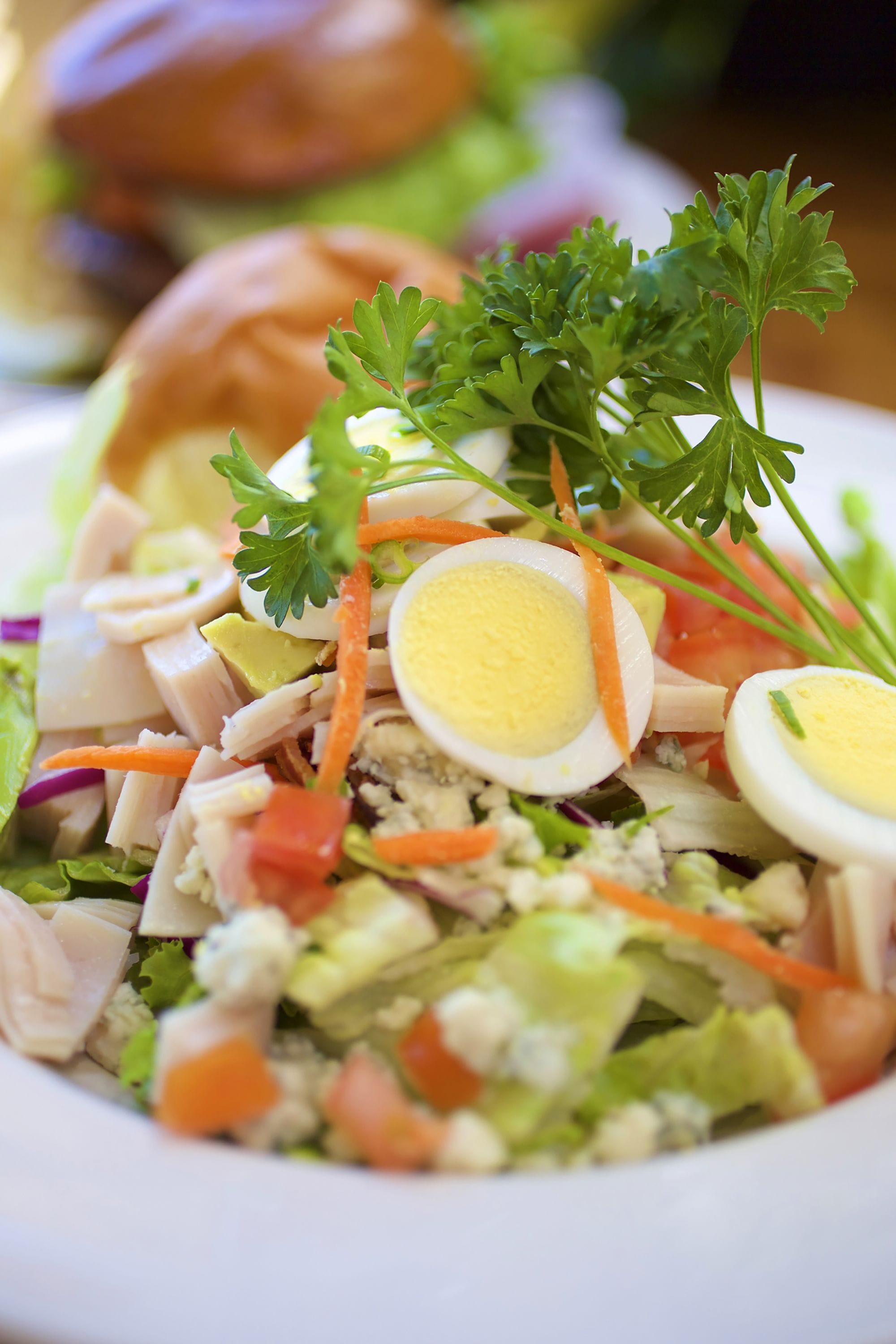 A salad with various ingredients including lettuce, carrots, and eggs.
