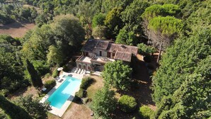 Vue aérienne d’une villa dotée d’une piscine, entourée d’une végétation luxuriante.