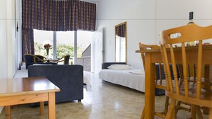 A room with a bed, a table, a chair, and a window with curtains. - Eliofos Elegant Maisonettes (Polis)