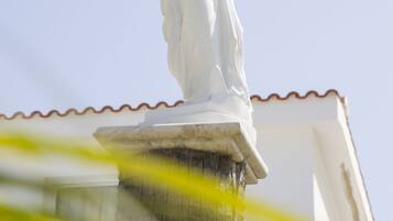 A white statue on a building's roof.