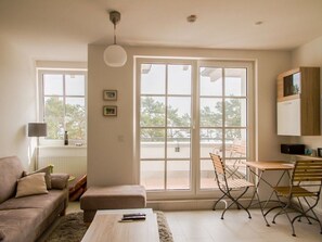 Una sala moderna con un sofá, una mesa de centro y un comedor con sillas.