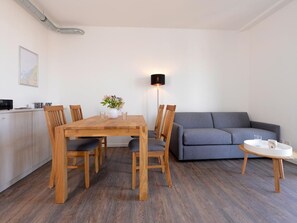 En moderne stue med spisebord, stole, sofa og lampe.