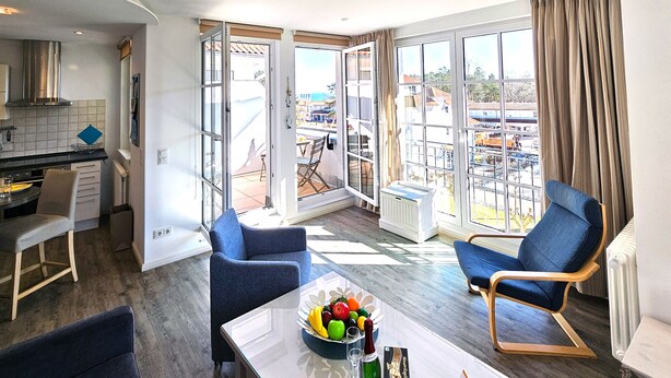 Un salon moderne avec un coin repas, de grandes fenêtres et une vue sur la ville.