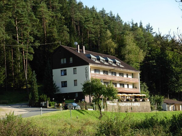 A two-story building with a sign 'GASTHOF' and 'RABENECK' indicating a guesthouse or hotel.