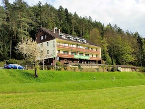 A multi-story building with a sign for 'GASTHOF WALDPENSION RABENECK' and a restaurant named 'cafe & restaurant'.