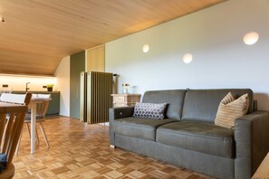 Ein gemütlicher Wohnbereich mit einer Couch, einem Esstisch und einer Heizung.