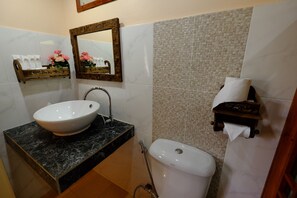 A bathroom with a marble sink, a toilet, and a mirror. - Lee Wine Ruk Thai Resort (Mae Hong Son)
