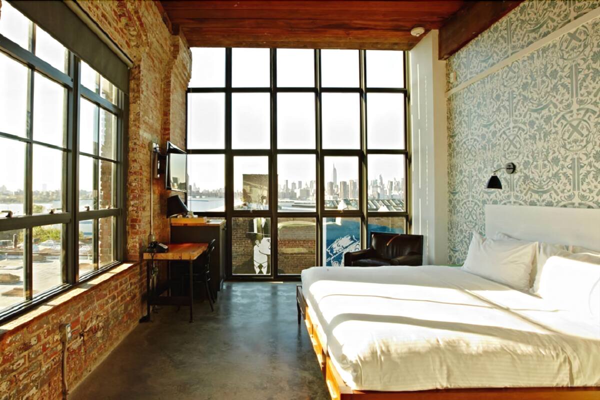Un dormitorio con un ventanal grande, un escritorio y una cama.