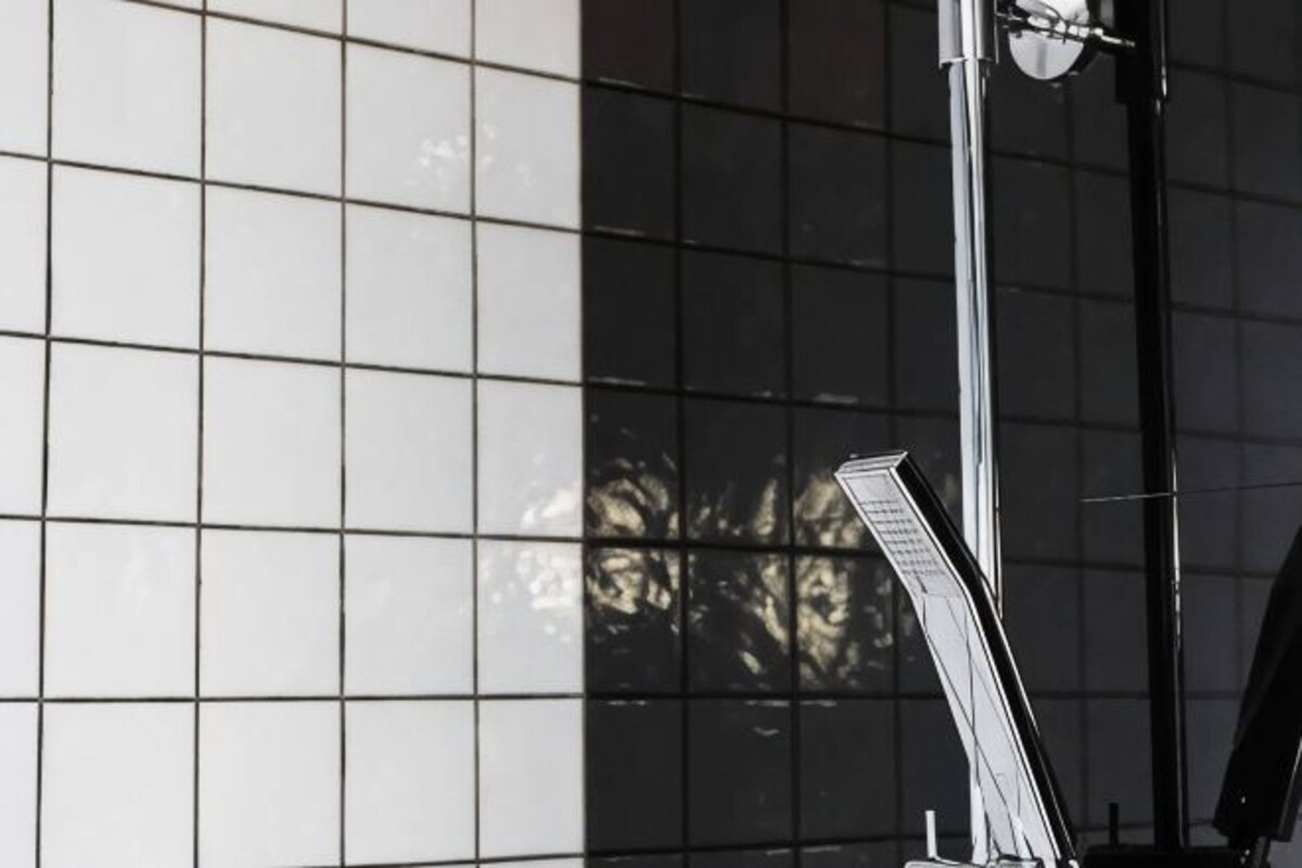 Un mur recouvert de carreaux, avec une structure métallique verticale.