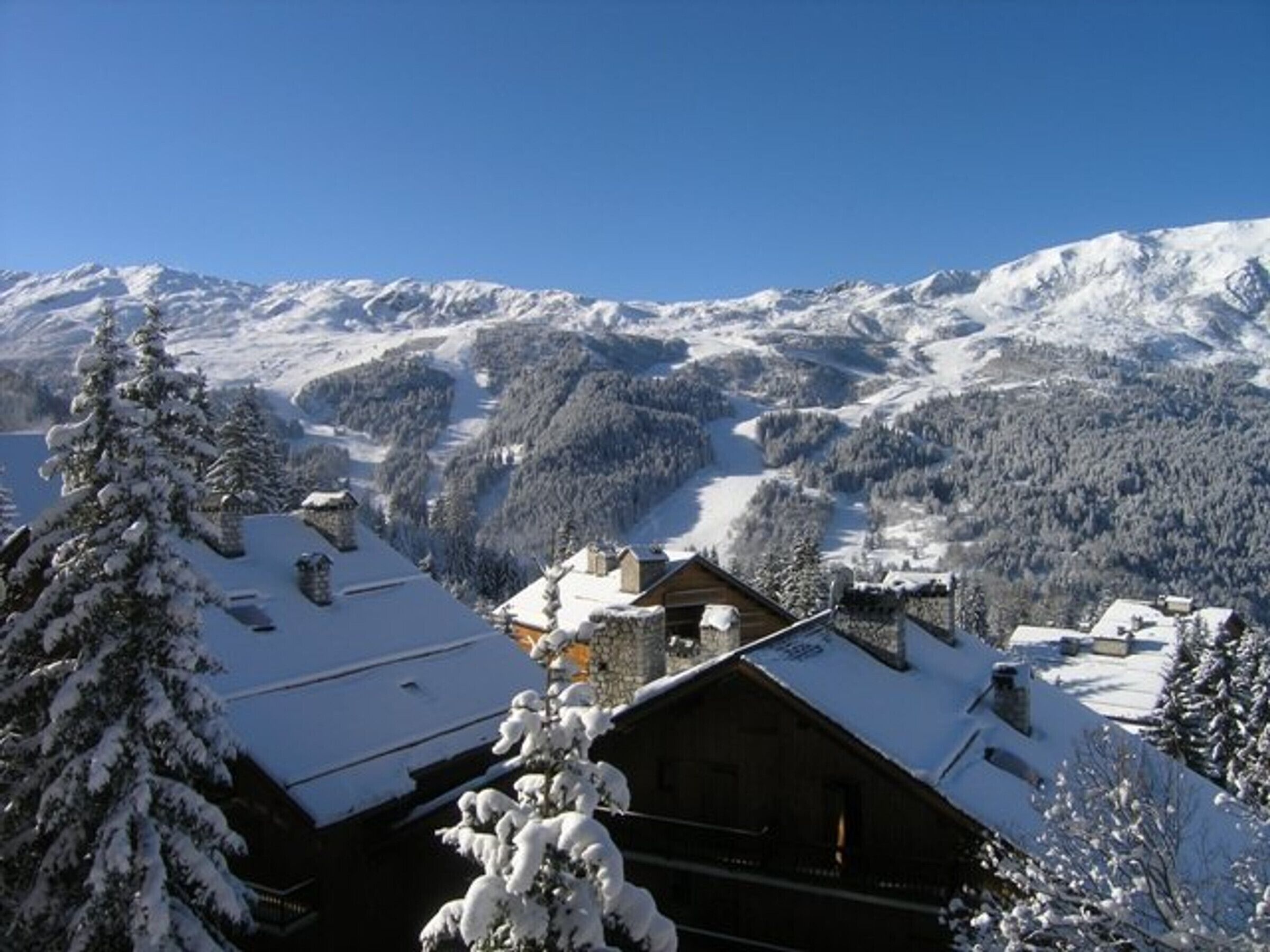 A snow-covered mountain landscape with a wooden cabin in the foreground.