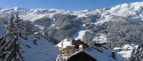 A snow-covered mountain landscape with a wooden cabin in the foreground.