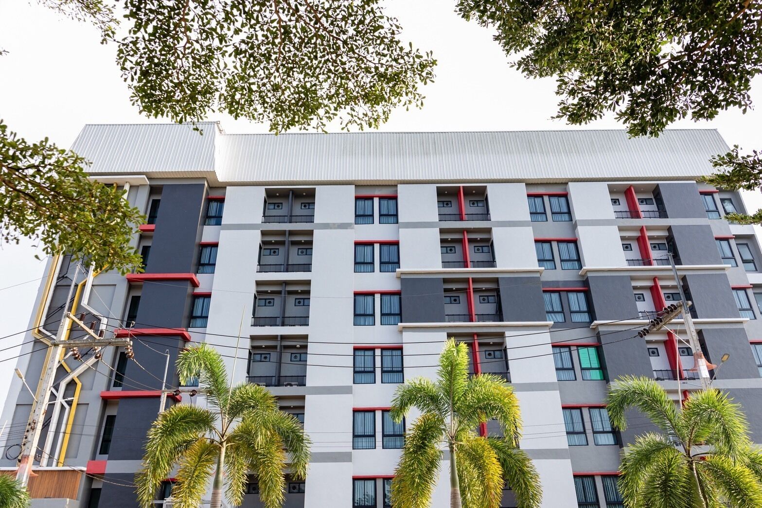 A multi-story building with a modern architectural design, featuring a grid of windows and balconies.