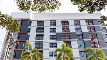 A multi-story building with a modern architectural design, featuring a grid of windows and balconies.