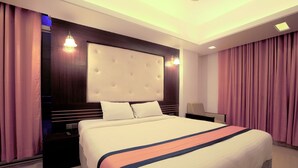 A modern hotel room with a large bed, a wooden headboard, and a nightstand. - The Cox Beach Resort (Cox's Bazar)