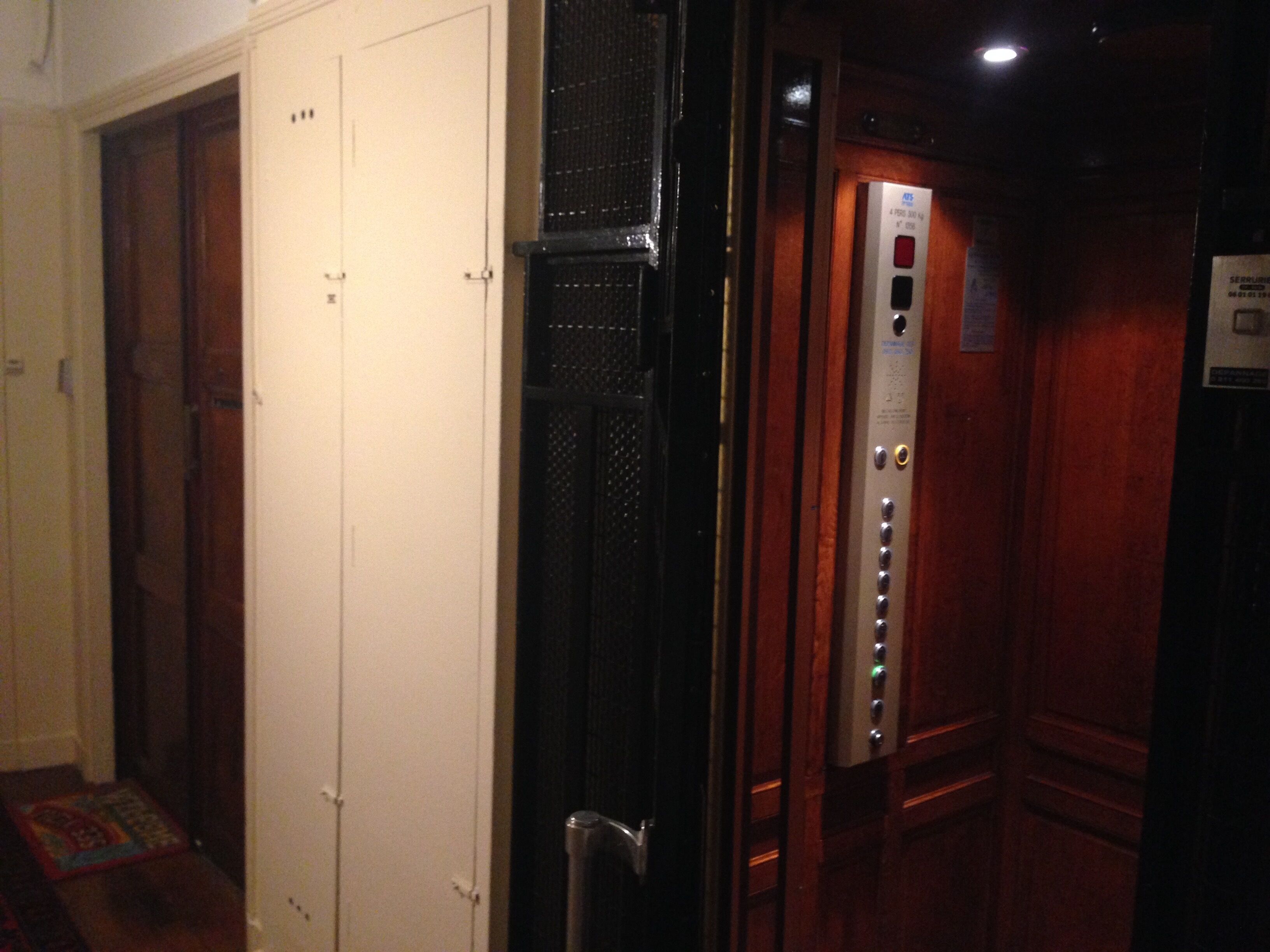 An elevator with a control panel and a door with a handle.