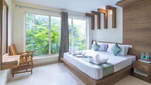 Une chambre d’hôtel moderne avec une grande fenêtre, un lit en bois, une table de chevet et une chaise.