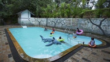 Relax by the pool surrounded by lush greenery and enjoy a fun-filled day with family.