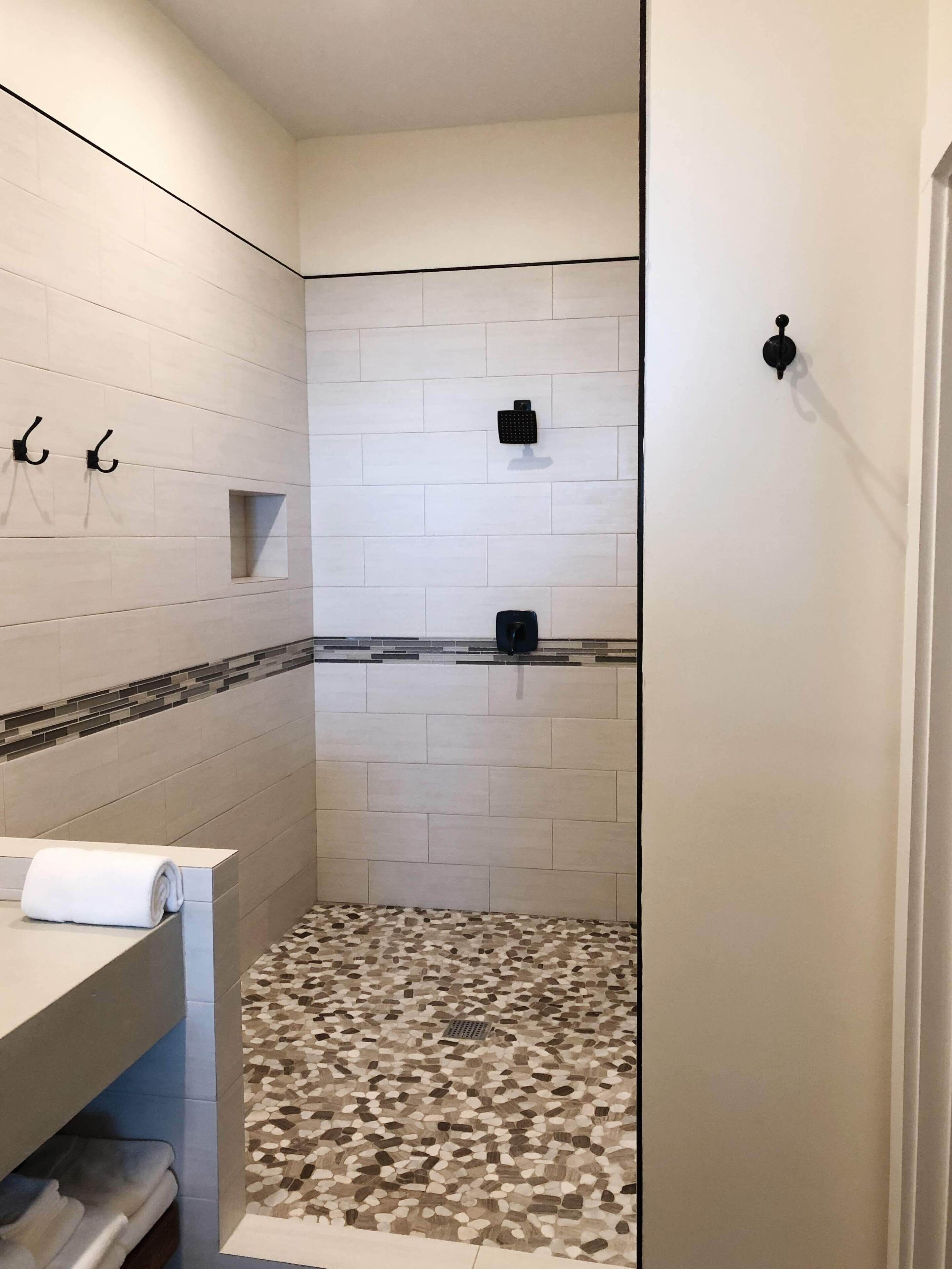 Een badkamer met een douche, toilet en wastafel.