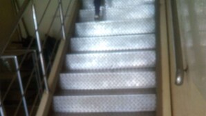 Eine Treppe mit Metallgeländern und einem gemusterten Boden.