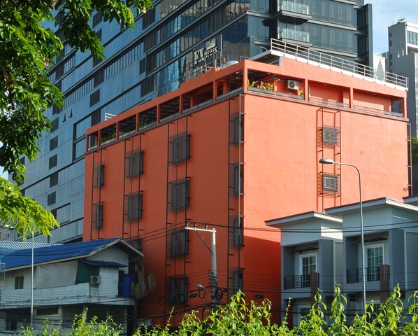 A multi-story building with a prominent orange facade, large windows, and a visible sign that reads "Kyoto." - Express Hostel (Bangkok)