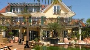 A two-story house with a balcony, a swimming pool, and outdoor furniture. - Pension Am Bodensee (Kressbronn)