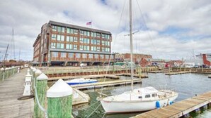 Un edificio frente al agua con un muelle y un barco.