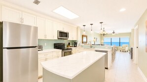 A modern kitchen with a large island, stainless steel appliances, and a view to the ocean. - Pier!! Use a private fishing pier!  Direct Gulf View - Pool (Orange Beach)
