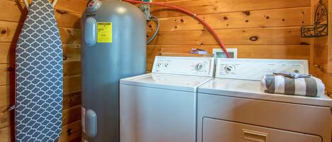 A laundry room with a large water heater, a washing machine, and a dryer.