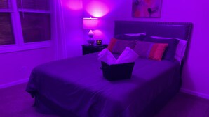 A bedroom with a bed, a nightstand, a lamp, and a digital clock displaying 5:58.