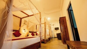 Una habitación con cama con dosel, un banco de madera y un televisor en la pared.