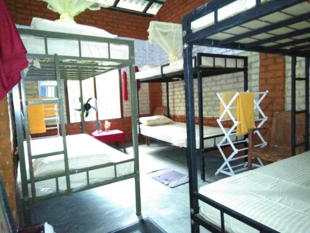 Une chambre de dortoir avec des lits superposés, une petite table et une chaise.