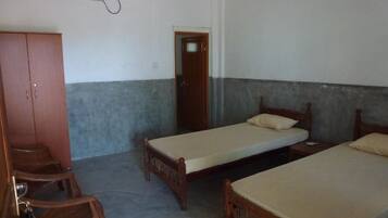 Una habitación con dos camas de madera, un armario de madera y un escritorio.