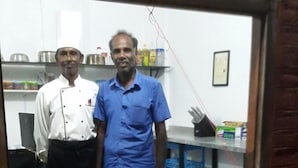 A restaurant interior with a wooden table displaying a variety of dishes. - Reef Pasikudah (Nasuvantivu)