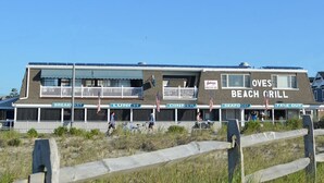 A beachfront building with sections labeled for breakfast, lunch, dinner, seafood, and takeout.