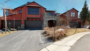 A two-story house with a stone facade, a garage, and a driveway.