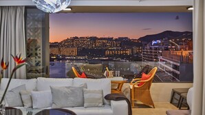 A modern living room with a city view, a white sofa, wicker chairs, and a glass table. - Wake up to Gorgeous Ocean Views from this Chic Apartment (Patalavaca)