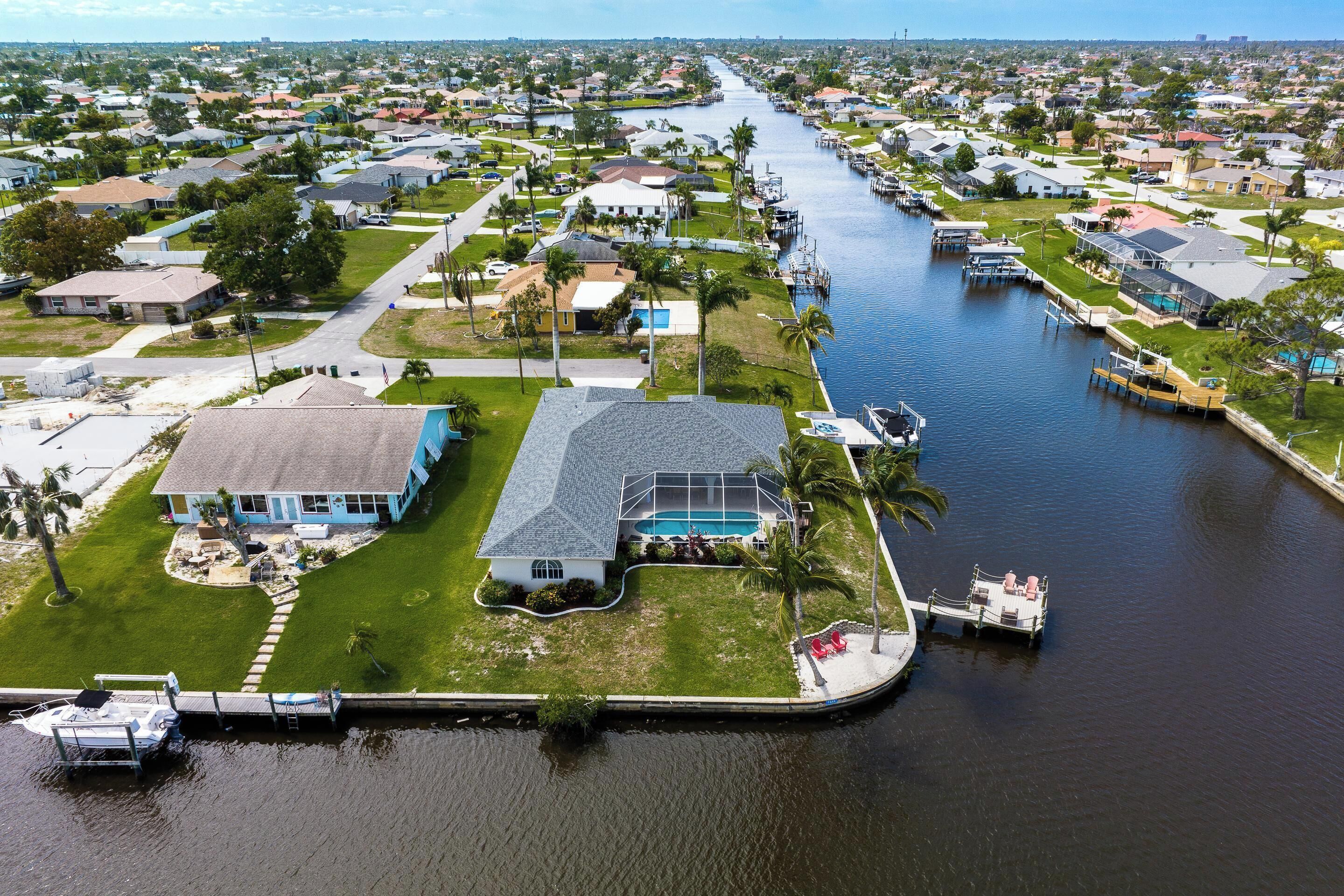 A residential area with houses along a waterway, docks, and a boat.