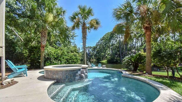 A swimming pool with a hot tub, surrounded by palm trees and a clear blue sky. - No Expense Spared - This Home is Perfect! (Hilton Head)