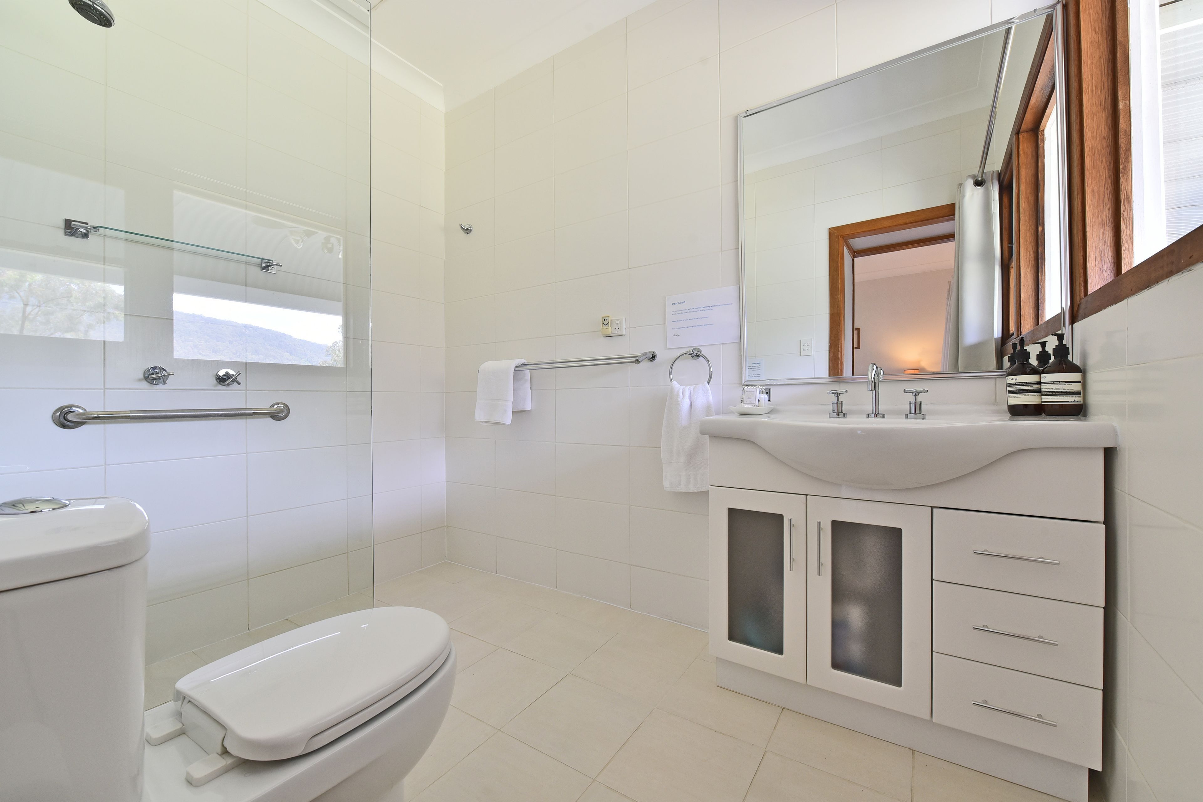 A modern bathroom with a toilet, sink, and shower.