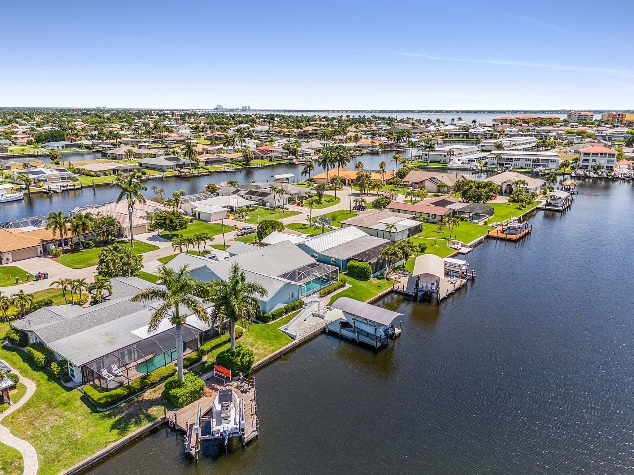 Una zona residencial con casas, un puerto deportivo y una masa de agua.