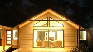 A two-story house with a large glass door entrance, wooden exterior, and a small deck area. - Braidwood Escape Denmark (Denmark)