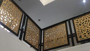 Interior com vários níveis, painéis dourados decorativos e iluminação embutida.