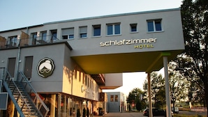 A modern hotel building with a prominent sign reading "Schlafzimmer Hotel". - Schlafzimmer Hotel (Dinkelsbuehl)