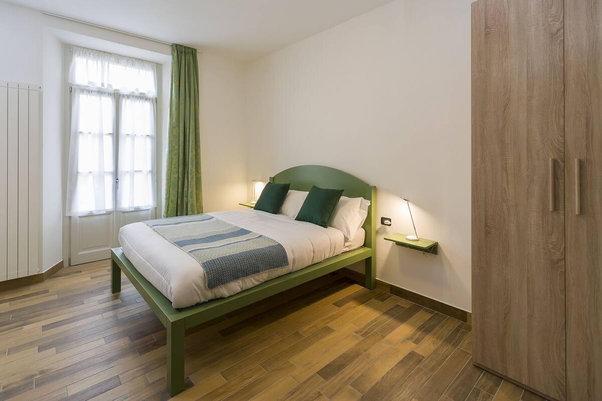 Une chambre bien rangée, avec un lit, une table de chevet et une armoire.