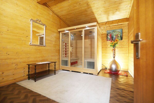 L’intérieur d’un chalet en bois, avec un banc en bois, un sauna et un miroir au mur.