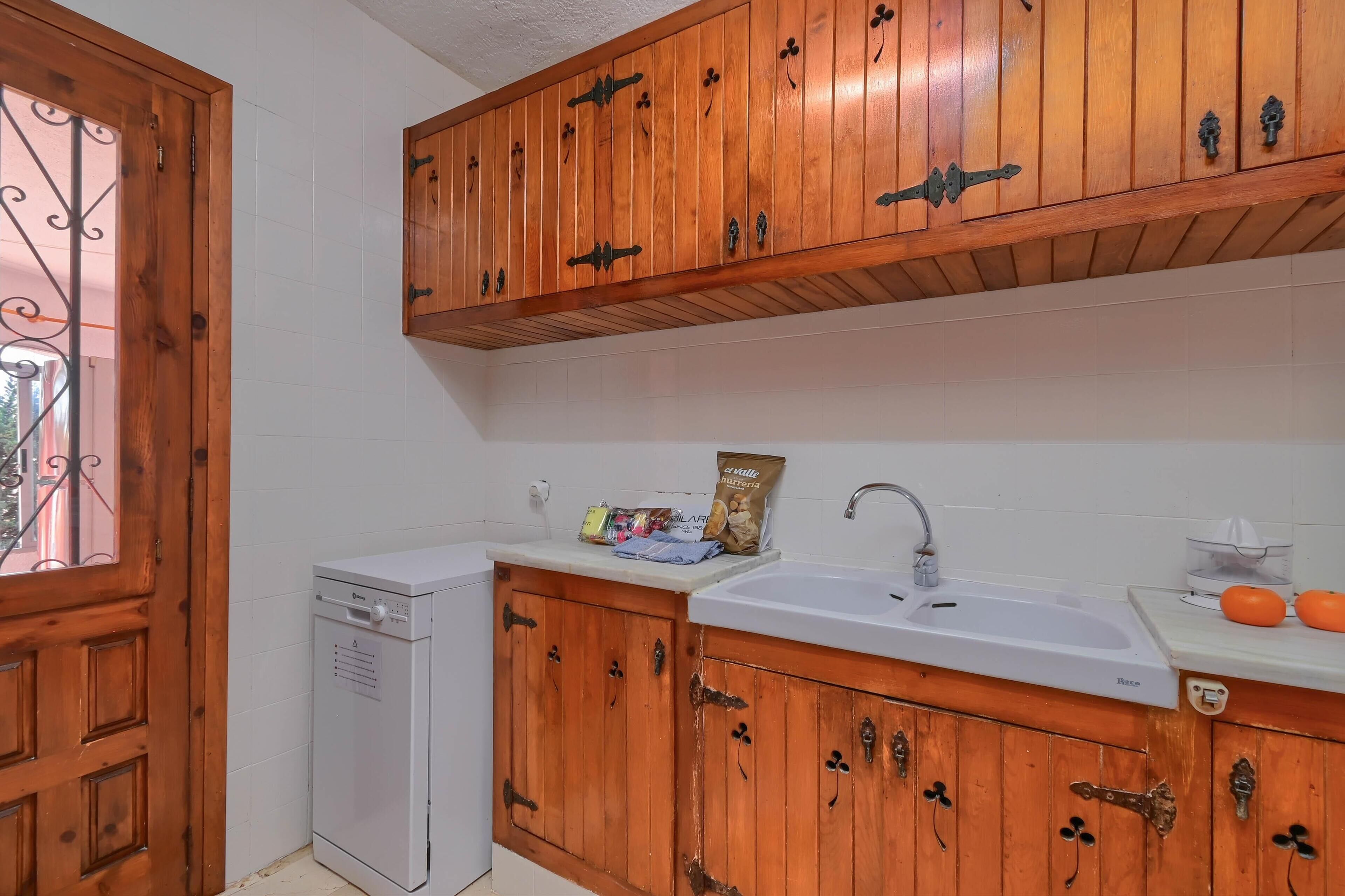 A kitchen with wooden cabinets, a dishwasher, and a sink.